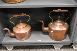 Two large 19th-century copper and brass fireside kettles, both feature acorn-shaped finials, swan-