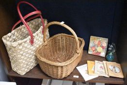 Two vintage wicker and straw baskets, one featuring red leather handles; sold with a small selection