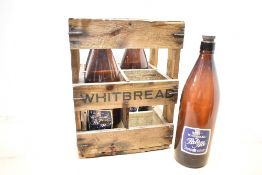 A 20th-century wooden Whitebread beer crate containing four empty bottles of Whitebread pale ale,