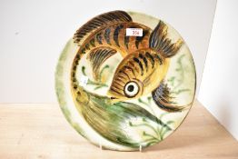 A large mid-20th-century Spanish Puigdemont studio pottery charger, depicting a stylised fish in