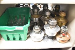 A collection of nine 20th-century Aladdin mantel oil lamps of varying metals, sold together with a