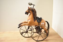 A decorative metal and carved wooden horse form model tricycle, with carved and painted features,