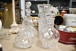 Six pieces of cut crystal and glass, comprising three decanters and three vases, each of differing