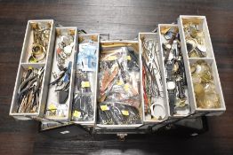 A 20th century folding/concertina tool box containing a quantity of watch related spares, straps,