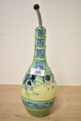 A contemporary ceramic cruet bottle, having colourful tube-lined decoration of abstract floral and