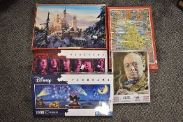 A new and unopened 1000 piece Disney jigsaw puzzle sold alongside four other used jigsaw puzzles