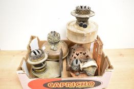 A Victorian oil lamp having a clear glass reservoir and metal base and two wall mounted oil lamps