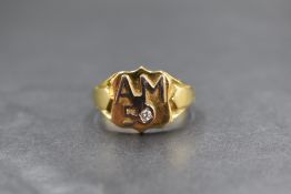 A gent's 18ct gold signet ring bearing appliqu? monogram AM 50 and small inset diamond to shield