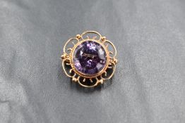 A 9ct gold amethyst brooch of circular form having an open petal and ball surround, approx 25mm