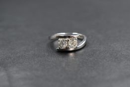 An 18ct white gold diamond set cross over ring, the two old cut diamonds measuring approximately 0.
