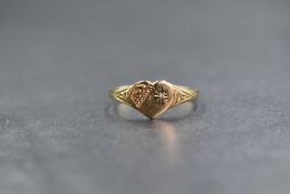 A 9ct gold diamond set signet ring, the heart motif panel having scroll engraving and a star set