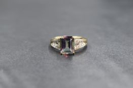 A 9ct gold mystic topaz ring having a single emerald cut stone in a four claw set mount to split gem