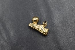 A yellow metal football boot and ball charm, no marks but presumed gold, approx 1g