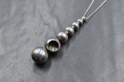 A Georg Jensen silver 'Cave' necklace, the pendant having seven graduated beads with the sixth