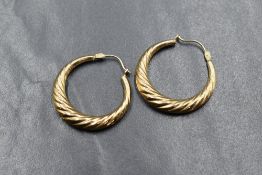 A pair of yellow metal hoop earrings of moulded twist form, approx 1.9g