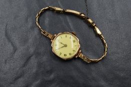 A 9ct gold cased wristwatch, the white dial having Roman numerals, with a yellow cover, the case