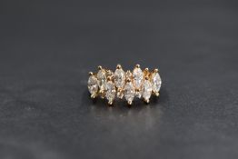 A yellow metal ring stamped 14K having eight marquise cut and six small round cut cubic zirconia