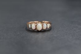 A 9ct rose gold opal set five stone ring, the graduated oval cabochons in claw settings, marked 375,