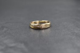 A 9ct gold band ring having an inset diagonal line of small diamonds, size P & approx 2.4g