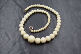 A single row of white coral beads, the circular graduated beads measuring between 1.5cm and 0.3cm,