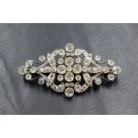 An early 20th century white metal diamond set brooch, the bezel set old cushion, round and