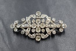 An early 20th century white metal diamond set brooch, the bezel set old cushion, round and