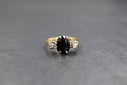 An 18ct gold sapphire and diamond set trilogy ring, the central oval cut sapphire measuring