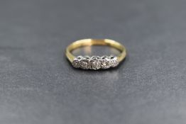 An 18ct gold diamond set five stone ring, the graduated round brilliant cut diamonds in illusions