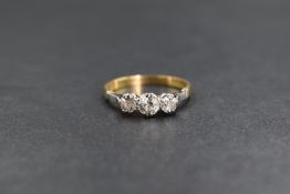 An 18ct gold diamond set three stone ring, the central old cut diamond measuring approximately 0.