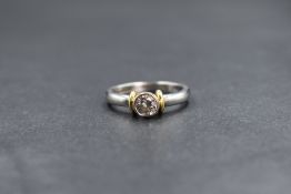 An 18ct white gold diamond set solitaire ring, the central round brilliant cut diamond in a bezel