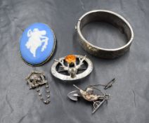 A white metal paste set novelty brooch, depicting a dog with red paste eyes within a kennel, along