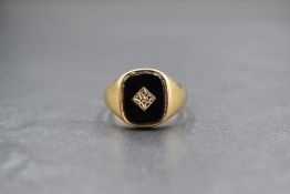 A gent's 9ct gold signet ring having a diamond set black onyx panel, size T & 5.3g