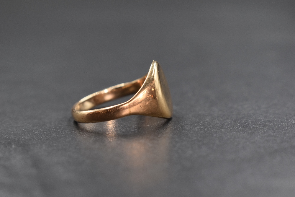 A yellow metal presumed gold signet ring, having an oval panel of plain form, unmarked, ring size S, - Image 2 of 3