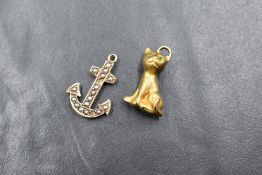 A 9ct gold cat charm, the cat displayed in a sitting position with green paste eyes marked 375,