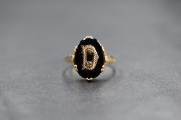 A 9ct gold mourning ring, the oval onyx panel having a 'D' initial to the centre, marked 375, ring
