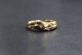 A 9ct gold diamond set band, having an intertwining motif set with five diamond chips, marked 375,