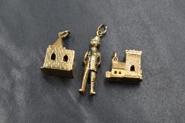 A group of three 9ct gold charms, comprising a policeman with an articulated head, and two