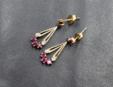 A pair of 9ct gold earrings for pierced ears having ruby set studs with ruby and diamond set