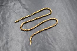 A yellow metal presumed gold necklace, the yellow metal beads testing as high carat gold with a