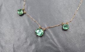 A 9ct gold paste set necklace, the paperclip link chain having three graduated cushion cut green