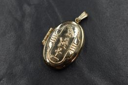 A 9ct gold locket, of oval form having Egyptian hieroglyphics to the front, written to the