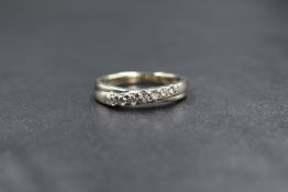 A 9ct gold band ring having a diagonal line of seven small diamonds, approx 0.30 ct total in a