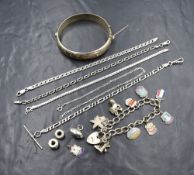 A selection of silver including a charm bracelet having seven enamelled souvenir shield and three