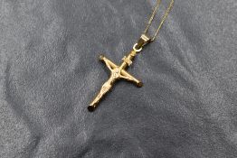 A 9ct gold crucifix pendant, on a fine 9ct gold chain, marked 9kt, 1.1g