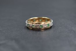 A 9ct gold emerald and diamond full eternity ring having ten small emeralds interspsersed with