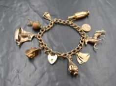 A 9ct gold charm bracelet having decorative twist links and padlock clasp and nine large gold charms
