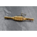 An 18ct gold bar brooch, having a woven and beadwork design with safety chain, marked 18 with