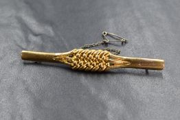 An 18ct gold bar brooch, having a woven and beadwork design with safety chain, marked 18 with