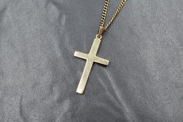 A 9ct gold cross pendant, of plain form on a long curb link chain, both marked 375, chain and