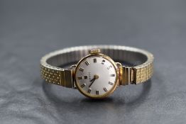 A lady's 9ct gold wrist watch by Tissot having a baton numeral dial to circular face in a plain gold